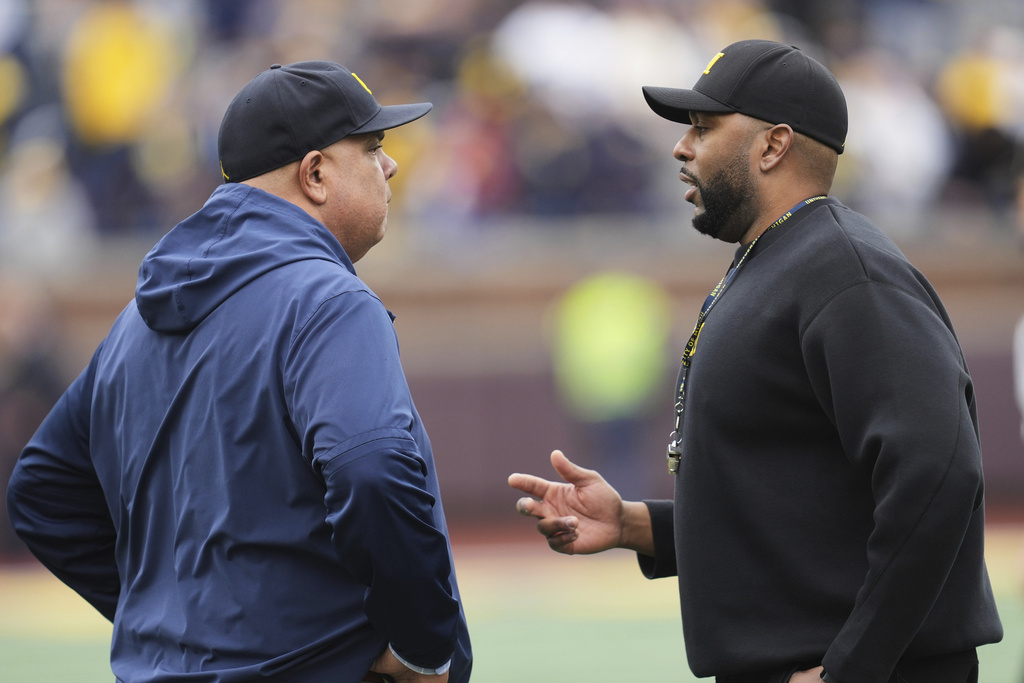 FILE - Michigan athletic director Warde Manuel, left, talks with head coach Sherrone Moore, right, before an NCAA college football spring game in Ann Arbor, Mich., April 19, 2025. (AP Photo/Paul Sancya, file)