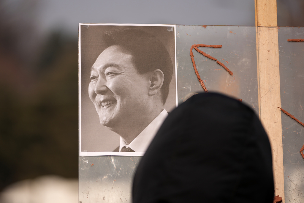 A picture of former South Korean President Yoon Suk Yeol is placed on a board as supporters gather outside Seoul Central District Court, in Seoul, South Korea, Friday, Jan. 16, 2026. (AP Photo/Lee Jin-man)