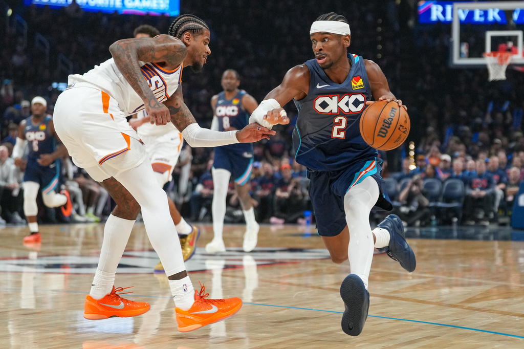 Oklahoma City Thunder guard Shai Gilgeous-Alexander, right, drives past Phoenix Suns guard Jalen Green during the second half in Game 2 of a first-round NBA playoffs basketball series Wednesday, April 22, 2026, in Oklahoma City. (AP Photo/Kyle Phillips)