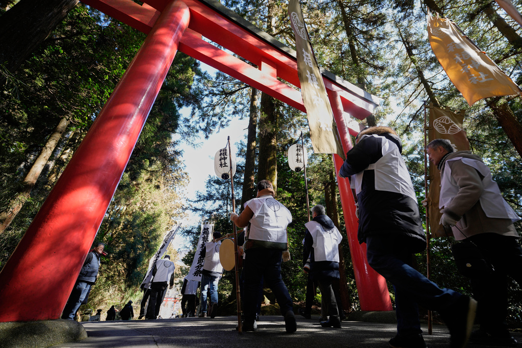 Participants march towards Lake Ashi near Hakone Shrine during the annual Bean Throwing Festival in Hakone, Japan, Tuesday, Feb. 3, 2026. (AP Photo/Eugene Hoshiko)