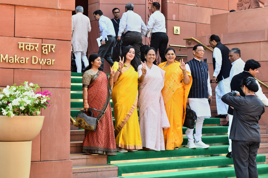 A security officer takes photograph of Indian women lawmakers as they pose outside Parliament House before the start of the debate on a landmark bill to reserve one-third of seats for women, in New Delhi, India, Thursday, April 16, 2026. (AP Photo)