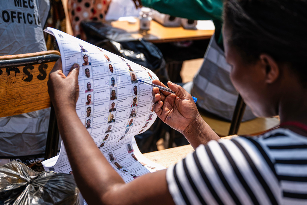 An election worker checks names in electoral rolls at a polling station in Thyolo District, Malawi, Tuesday, Sept. 16, 2025. (AP Photo/Thoko Chikondi)