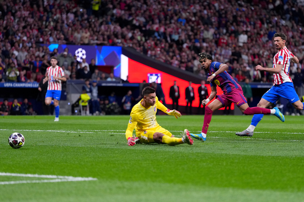 Barcelona's Lamine Yamal, center, scores the opening goal during the Champions League quarterfinal second leg soccer match between Atletico Madrid and Barcelona in Madrid, Spain, Tuesday, April 14, 2026. (AP Photo/Manu Fernandez)