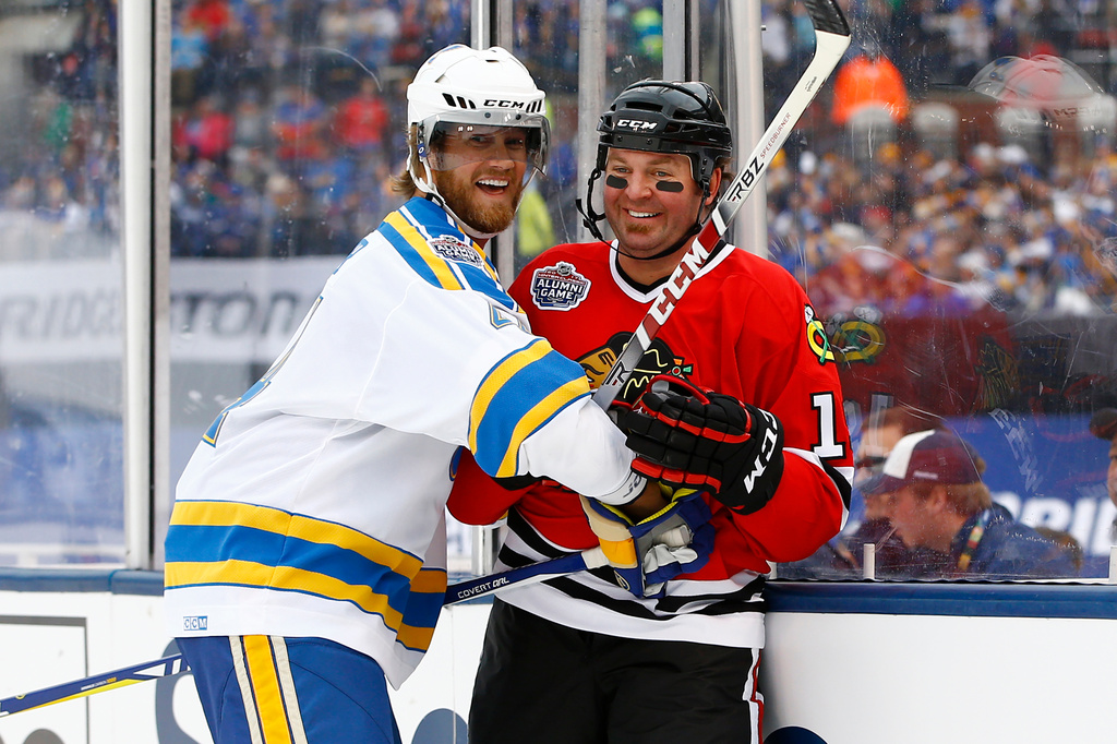 FILE - In this Dec. 31, 2016, file photo, former St. Louis Blues' Chris Pronger, left, laughs with former Chicago Blackhawks' Kyle Calder after a check during the Winter Classic alumni outdoor hockey game at Busch Stadium in St. Louis. (AP Photo/Billy Hurst, File)