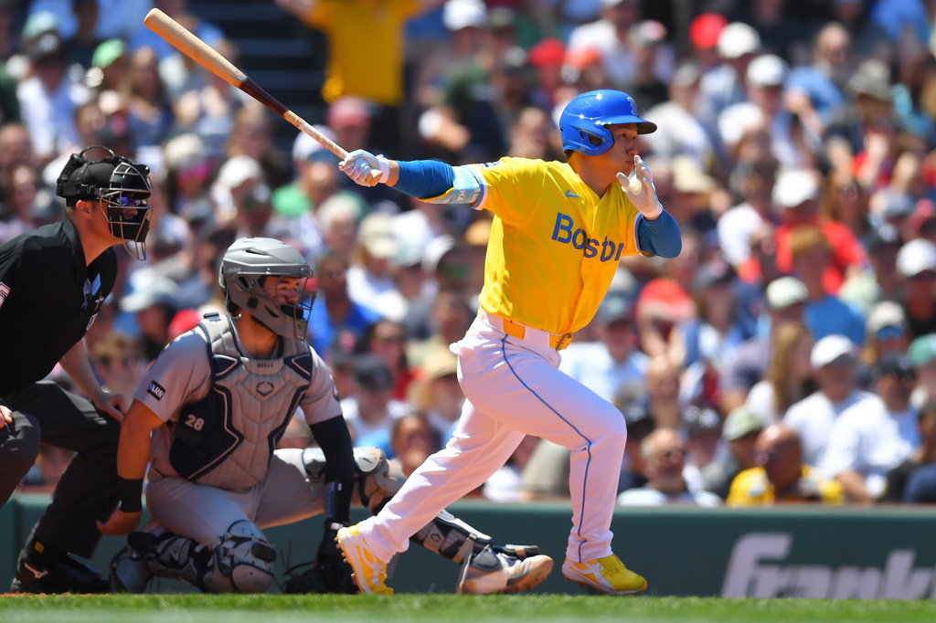 Boston Red Sox's Masataka Yoshida, right, follows through on his swing as he hits a single in front of New York Yankees catcher Austin Wells, center, in the third inning of a baseball game, Saturday, June 27, 2026, in Boston. (AP Photo/Steven Senne)