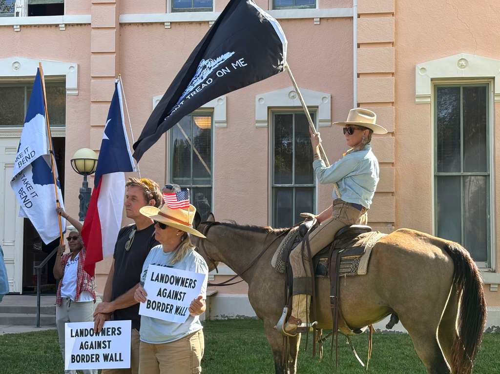 Landowners and other supporters hold signs against the Trump administration's plans to build a border wall and other infrastructure in Texas' remote Big Bend region, Monday, Sept. 14, 2026, in Marfa, Texas. (AP Photo/Rebecca Santana)
