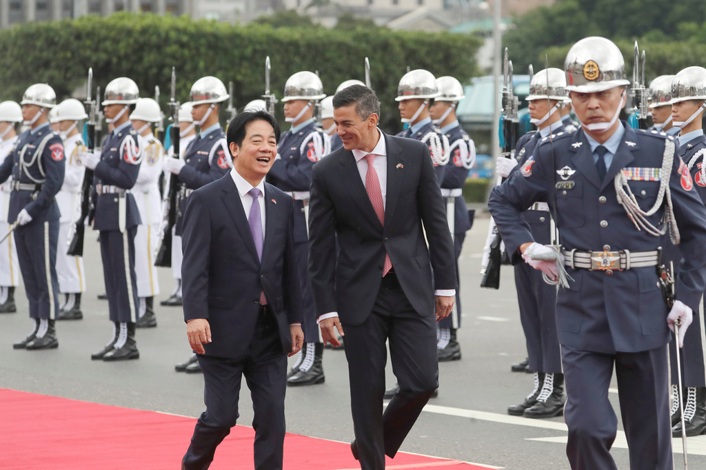 Paraguayan President Santiago Pena, center, accompanied by Taiwan President Lai Ching-te, left, reviews an honor guard at a military welcome ceremony in front of the president office in Taipei, Taiwan, Friday, May 8, 2026. (AP Photo/Chiang Ying-ying)