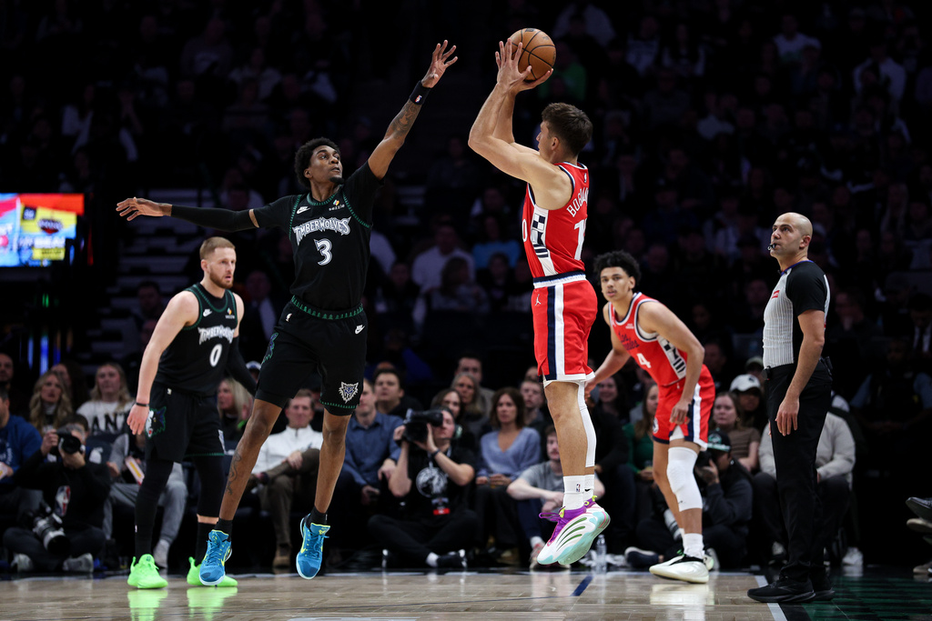 Los Angeles Clippers guard Bogdan Bogdanovic, right, shoots the ball as Minnesota Timberwolves forward Jaden McDaniels (3) defends during the first half of an NBA basketball game Saturday, Dec. 6, 2025, in Minneapolis. (AP Photo/Matt Krohn)