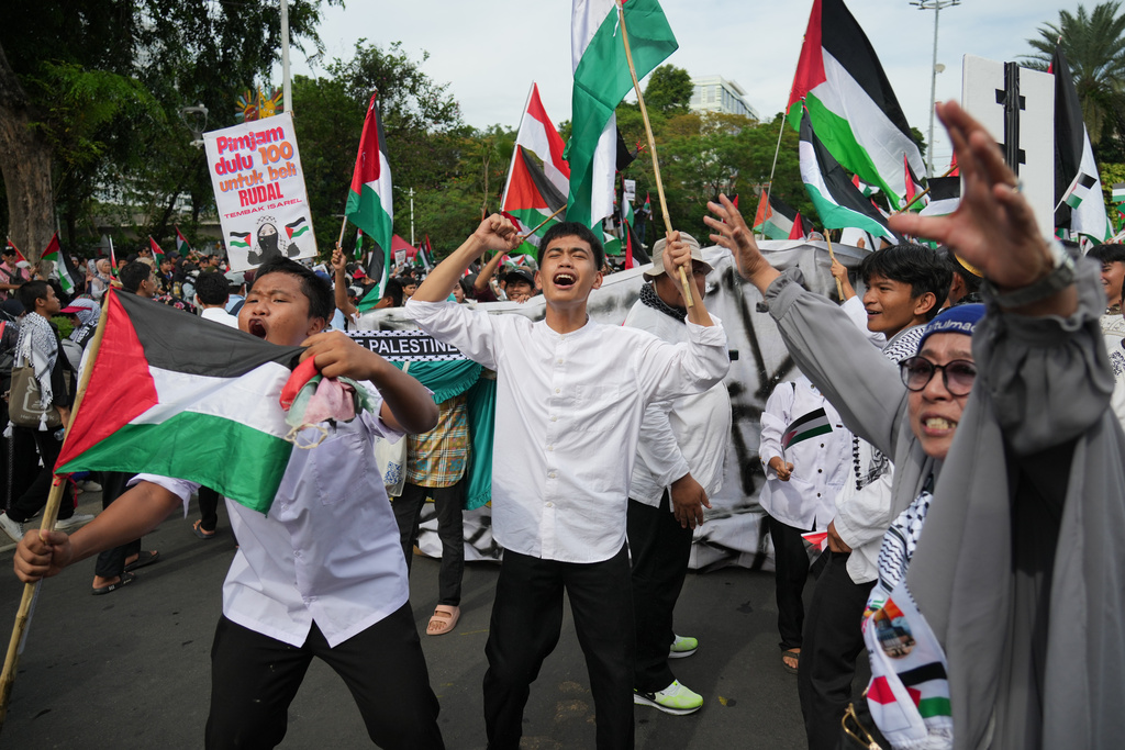 Protesters wave Palestinian flags as they shout slogans during a rally commemorating the second anniversary of the war in Gaza, outside the US Embassy in Jakarta, Indonesia, Tuesday, Oct. 7, 2025. (AP Photo/Achmad Ibrahim)