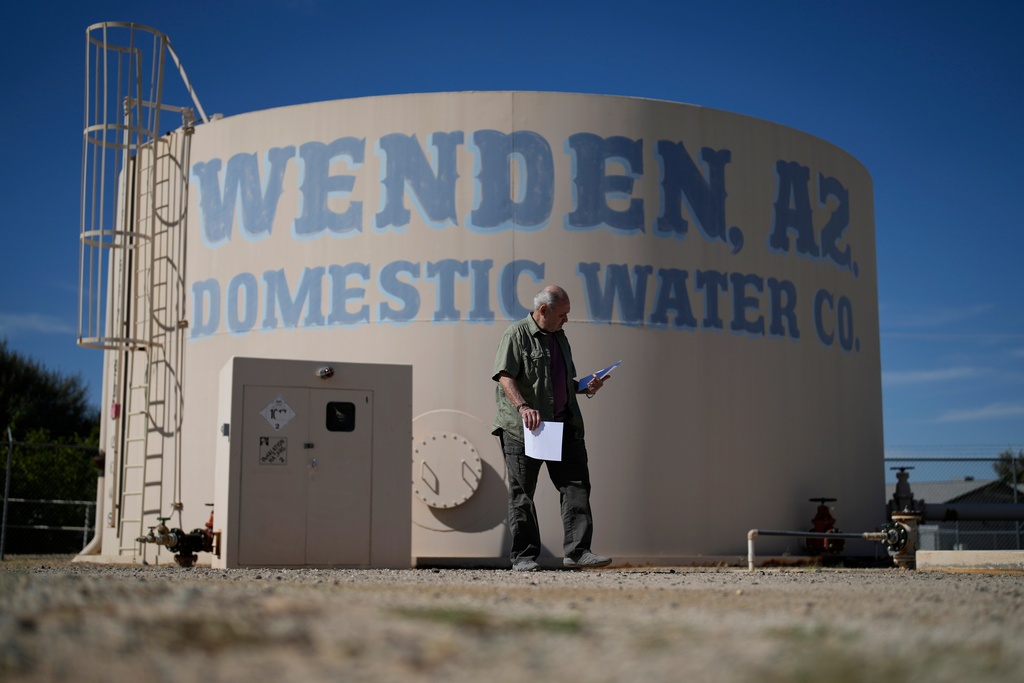 FILE - Gary Saiter, chairman of the board and general manager of the Wenden Domestic Water Improvement District, walks by a water tank at the district's well, Tuesday, Oct. 17, 2023, in Wenden, Ariz. (AP Photo/John Locher, File)