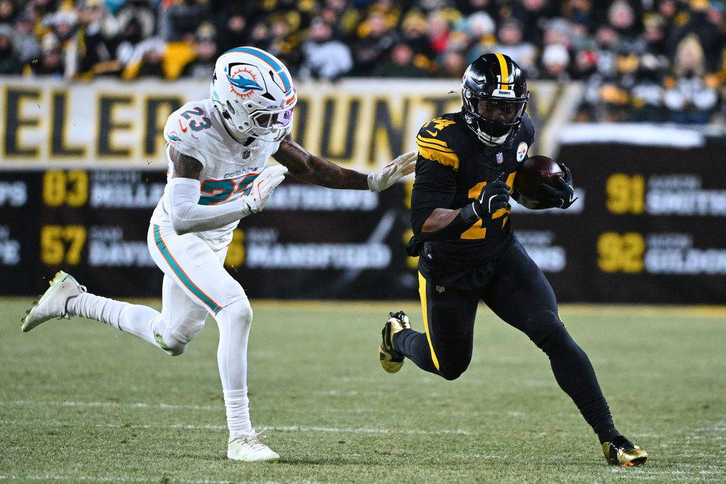 Pittsburgh Steelers running back Kenneth Gainwell (14) gains yards after a catch as Miami Dolphins' Jack Jones (23) defends in the first half of an NFL football game in Pittsburgh, Monday, Dec. 15, 2025. (AP Photo/Justin Berl)