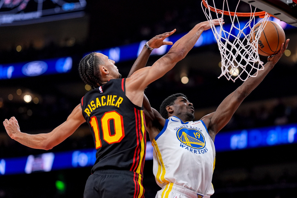 Golden State Warriors guard Nate Williams (19) shoots over Atlanta Hawks forward Zaccharie Risacher (10) during the first half of an NBA basketball game, Saturday, March 21, 2026, in Atlanta. (AP Photo/Mike Stewart)