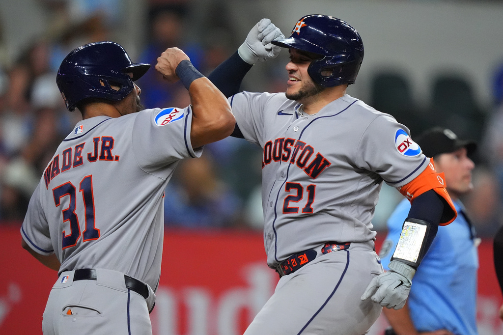 Houston Astros' Yainer Diaz (21) celebrates with teammate LaMonte Wade Jr. (31) after they both scored on a home run by Diaz during the seventh inning of a baseball game against the Texas Rangers, Friday, July 10, 2026, in Arlington, Texas. (AP Photo/LM Otero)