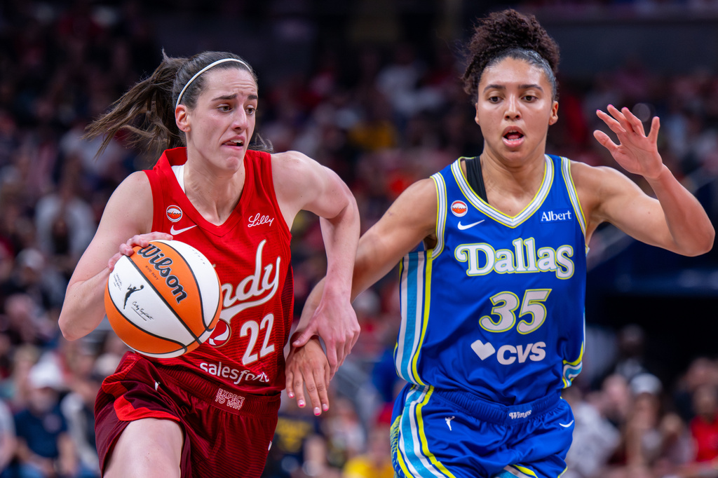 Indiana Fever guard Caitlin Clark (22) drives the ball past Dallas Wings guard Azzi Fudd (35) during the first half of an WNBA basketball in Indianapolis, Saturday, May 9, 2026. (AP Photo/Doug McSchooler)