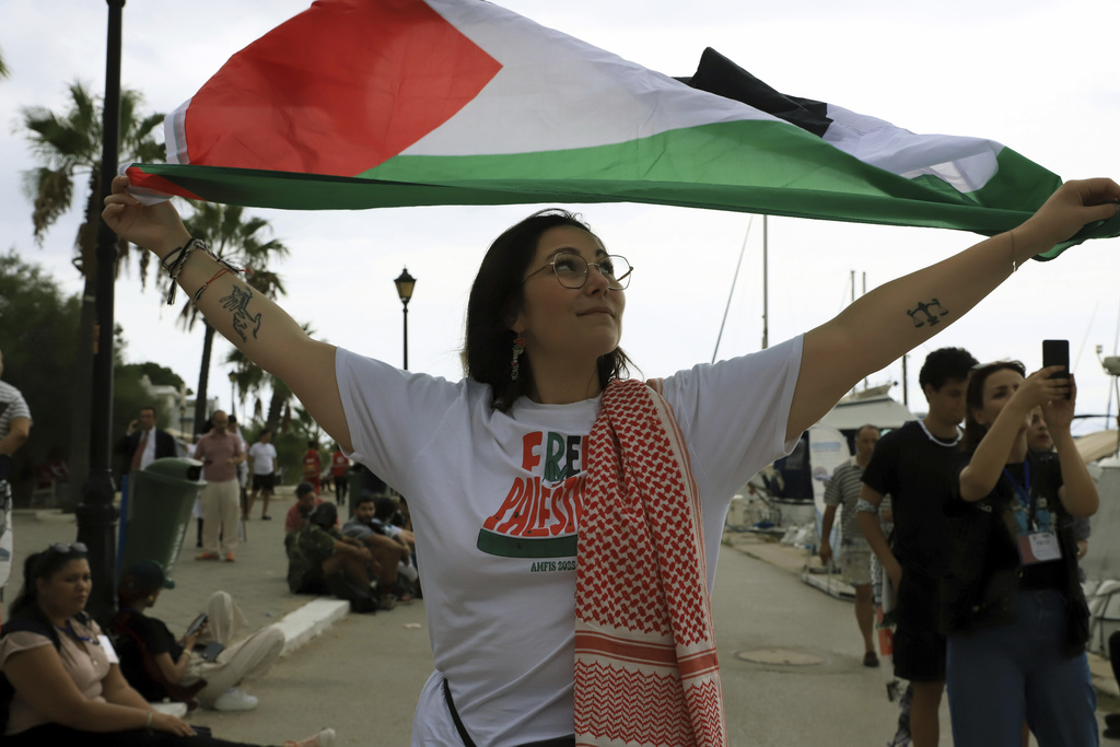 A French participant of the Global Sumud Flotilla holds a Palestinian flag ahead of the scheduled departure to the Gaza Strip to break Israel's blockade on the Palestinian territory, in Sidi Bou Said port in Tunis, Tunisia, Wednesday, Sept. 10, 2025. (AP Photo/Anis Mili)