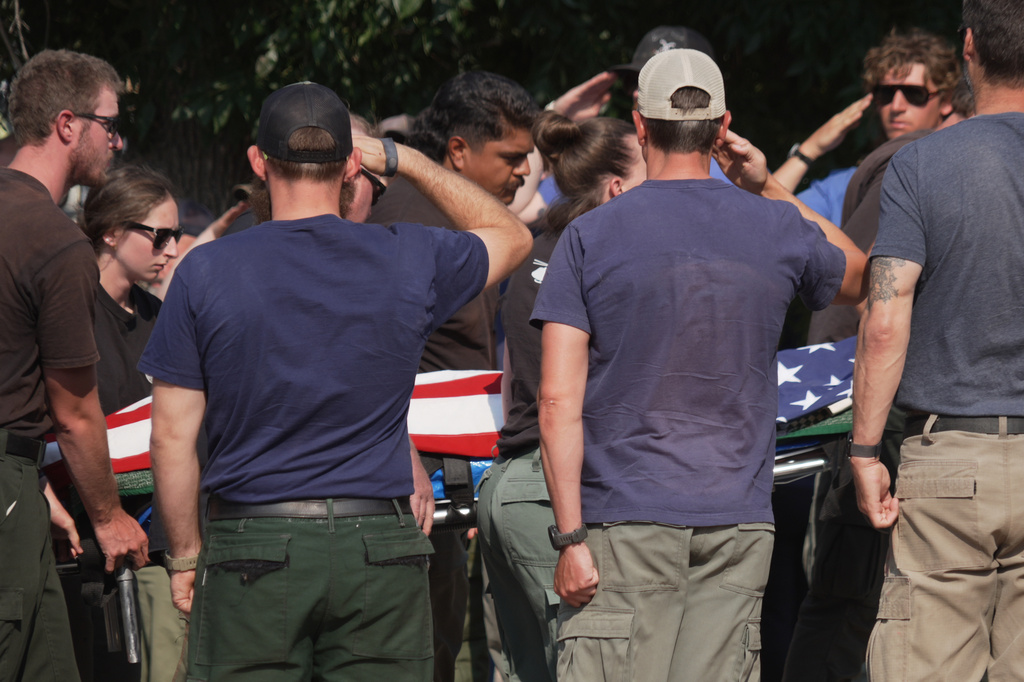 The body of a firefighter who died battling wildfires near the Colorado-Utah border is carried during a procession in Grand Junction, Colo., Monday, June 29, 2026. (AP Photo/Ty ONeil)