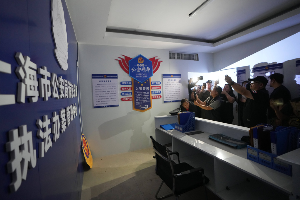 Thai media inspect what appears to be a mock-up set resembling a Chinese police station at a scam center in O'Smach, Cambodia, Monday, Feb. 2, 2026. (AP Photo/Sakchai Lalit)
