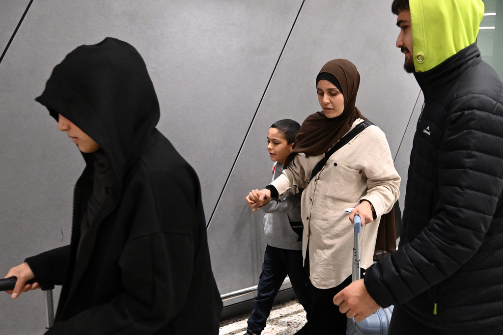FILE - A group of supporters surround a woman and child with alleged ties to the Islamic State as they arrive at Melbourne international Airport, in Melbourne, Australia, Thursday, May 7, 2026. (Joel Carrett/AAP Image via AP, File)