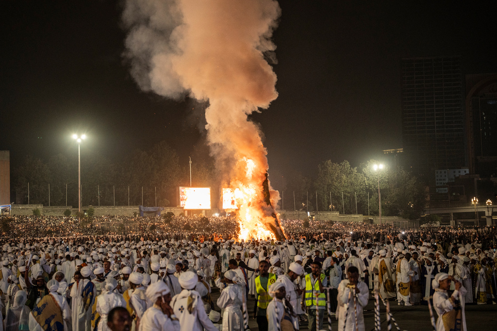 People chant as the bonfire lights during celebrations for the Orthodox holiday of Meskel, an annual holiday celebrating the discovery of the True Cross in the fourth century by the Roman Empress Helena, in Addis Ababa, Ethiopia, Saturday, Sept. 26, 2026. (AP Photo/Amanuel Sileshi)
