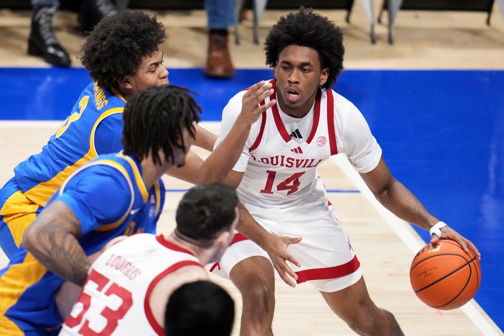 Louisville guard Adrian Wooley (14) is defended by Pittsburgh guard Brandin Cummings, top left, during the first half of an NCAA college basketball game in Pittsburgh, Saturday, Jan. 17, 2026. (AP Photo/Gene J. Puskar)