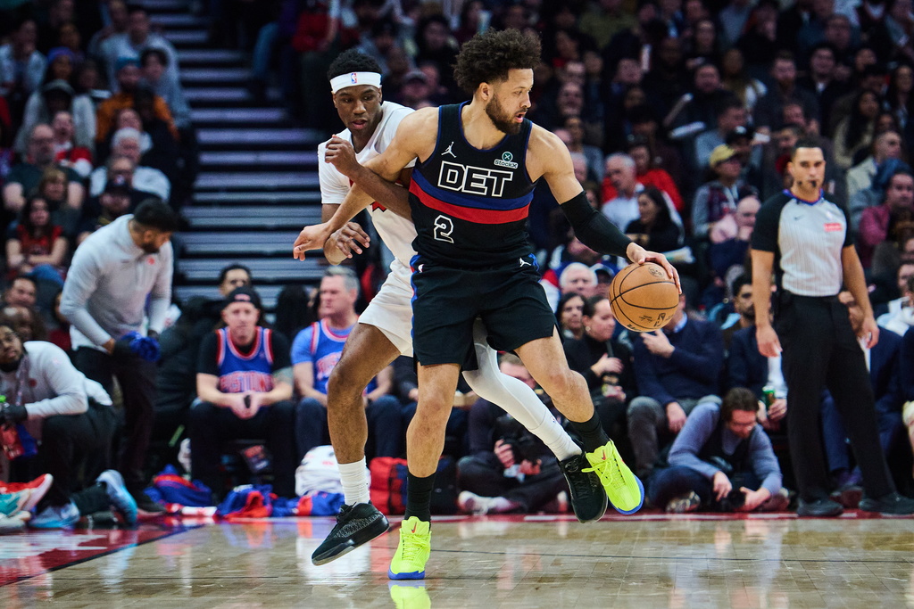 Detroit Pistons' Cade Cunningham (2) and Toronto Raptors' Ja'Kobe Walter (14) battle for the ball during the first half of an NBA basketball game in Toronto, Wednesday, Feb. 11, 2026. (Sammy Kogan/The Canadian Press via AP)