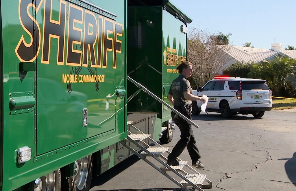 In this image taken from video provided by WFTS, law enforcement officers investigate a scene, Wednesday, Feb. 11, 2026, in Sarasota, Fla., which authorities say is connected to another crime scene, in Fort Lauderdale, Fla. (WFTS via AP)