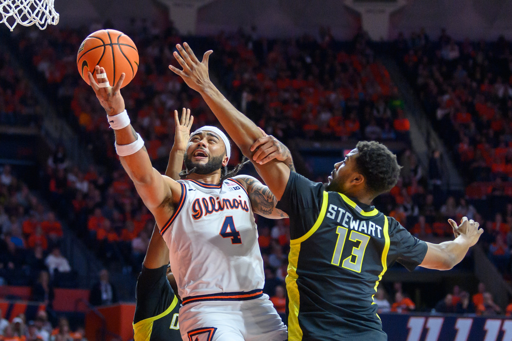 Illinois guard Kylan Boswell, center, goes up to the basket against Oregon's Sean Stewart during an NCAA college basketball game Tuesday, March 3, 2026, in Champaign, Ill. (AP Photo/Craig Pessman)