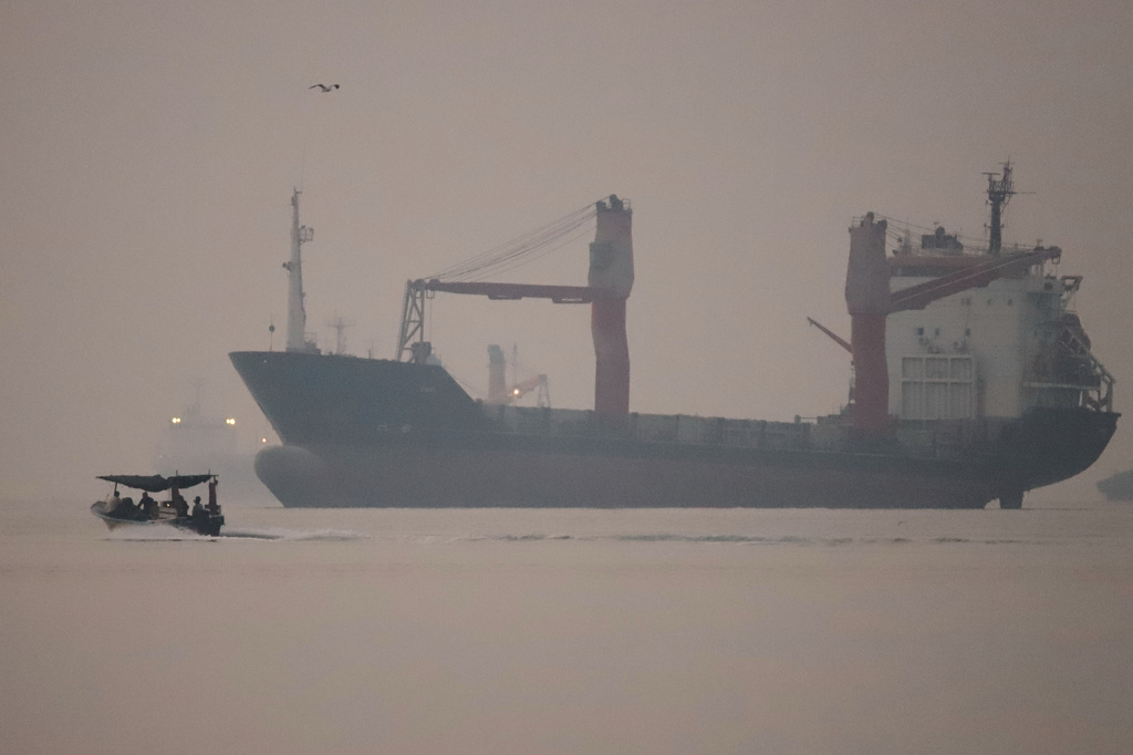 A motorboat passes an anchored cargo ship in the Strait of Hormuz off Bandar Abbas, Iran, early Monday, Sept. 28, 2026. (Amirhosein Khorgooi/ISNA via AP)
