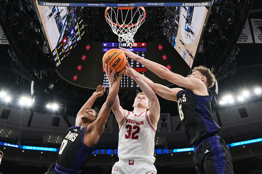 Wisconsin forward Aleksas Bieliauskas, center, battles for a rebound against Washington guard Quimari Peterson, left, and forward Hannes Steinbach during the first half of an NCAA college basketball game in the third round of the Big 10 Conference tournament Thursday, March 12, 2026, in Chicago. (AP Photo/Nam Y. Huh)