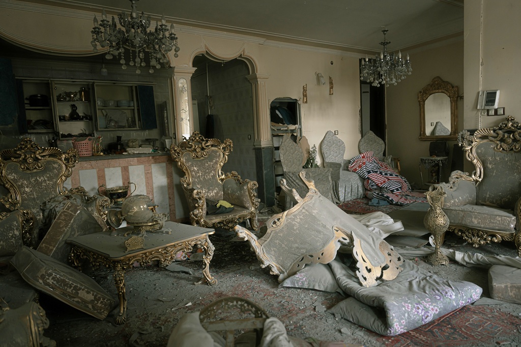 A damaged living room is seen in a house that was affected when a nearby residential building was hit in an overnight strike during the U.S.-Israeli military campaign in Tabriz, East Azerbaijan Province, northwestern Iran, Tuesday, March 24, 2026. (AP Photo/Matin Hashemi)