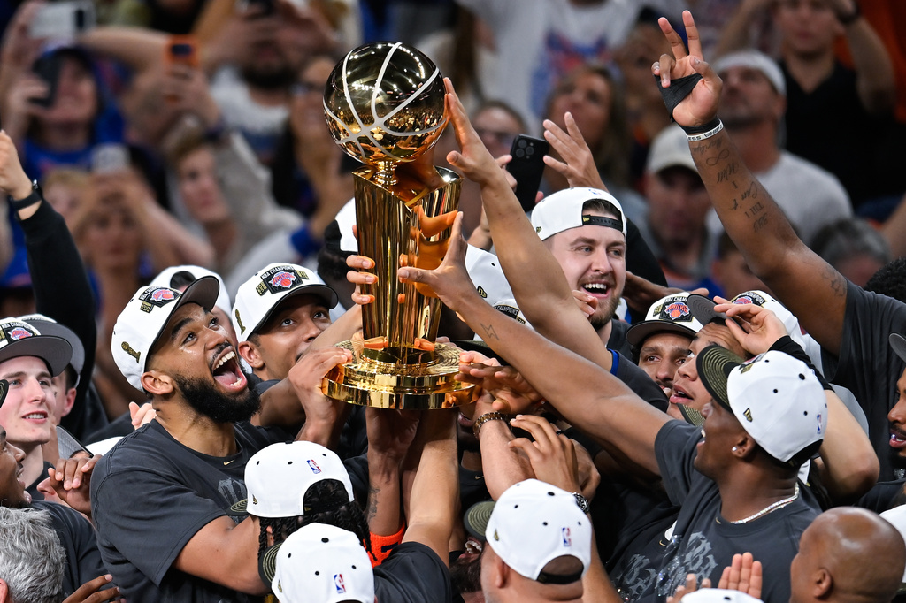 The New York Knicks celebrate with the Larry O'Brien Championship Trophy after defeating the San Antonio Spurs in Game 5 of the NBA Finals basketball series, Saturday, June 13, 2026, in San Antonio. (AP Photo/Darren Abate)