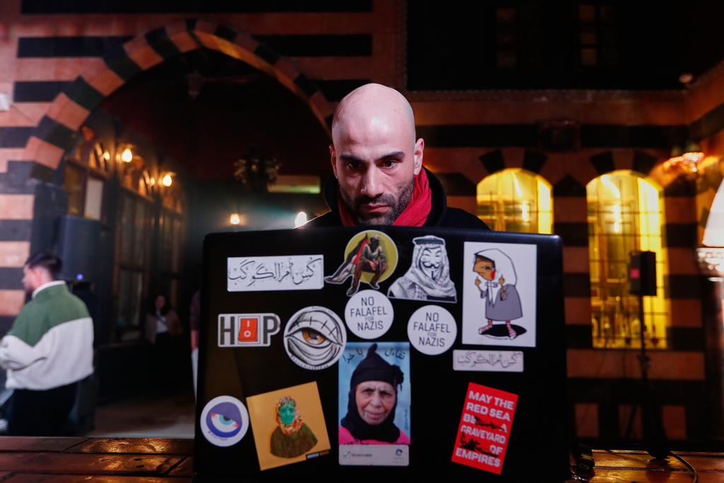 Hani Al Sawah, a Syrian rap artist known as Al Darwish, works on his laptop in old Damascus, Syria, Friday, Jan. 16, 2026. (AP Photo/Omar Sanadiki)
