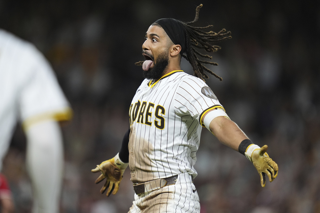 San Diego Padres' Fernando Tatis Jr. celebrates with teammates after hitting a game-winning sacrifice fly during the tenth inning of a baseball game against the Cincinnati Reds Monday, Sept. 8, 2025, in San Diego. San Diego Padres' Jake Cronenworth scored from third base on the play, and the Padres won 4-3. (AP Photo/Gregory Bull)