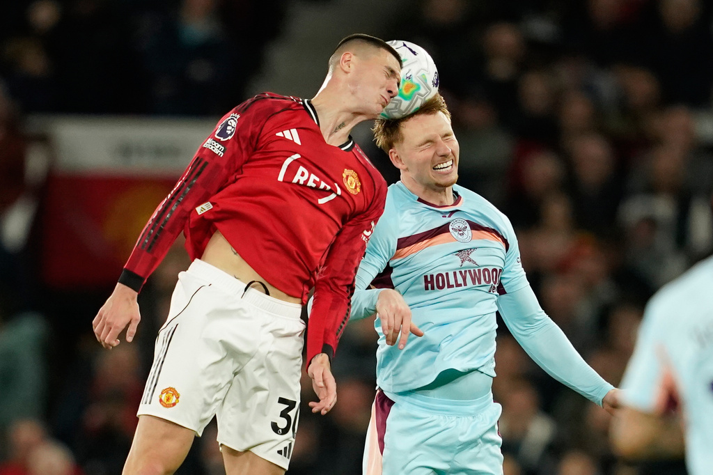 Manchester United's Benjamin Sesko, left, and Brentford's Sepp van den Berg jump for the ball during the Premier League soccer match between Manchester United and Brentford in Manchester, England, Monday, April 27, 2026. (AP Photo/Dave Thompson)