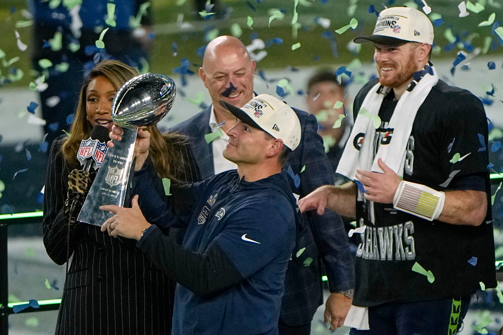 Seattle Seahawks head coach Mike Macdonald holds the trophy as quarterback Sam Darnold, right, and others look on after the team's win in the NFL Super Bowl 60 football game against the New England Patriots, Sunday, Feb. 8, 2026, in Santa Clara, Calif. (AP Photo/Charlie Riedel)