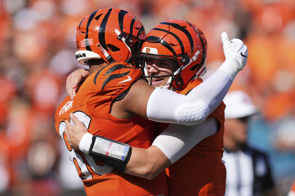 Cincinnati Bengals quarterback Jake Browning, right, is hugged by tight end Noah Fant after Browning's rushing touchdown during the second half of an NFL football game against the Jacksonville Jaguars, Sunday, Sept. 14, 2025, in Cincinnati. (AP Photo/Jeff Dean)