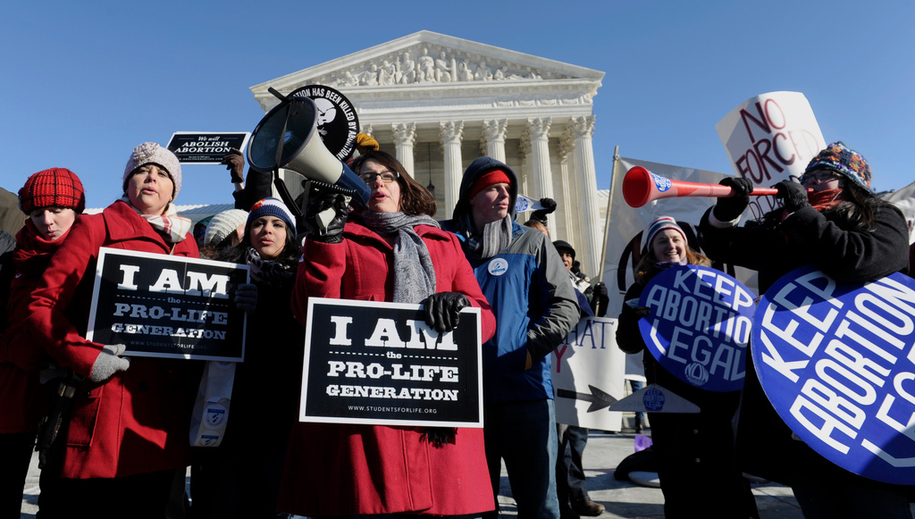 FILE - Pro-abortion and anti-abortion protestors rally outside the Supreme Court in Washington, Wednesday, Jan. 22, 2014, during the March for Life. (AP Photo/Susan Walsh, File)
