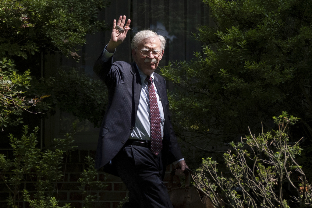FILE - Former national security adviser John Bolton waves as he arrives at his house Aug. 22, 2025, in Bethesda, Md. (AP Photo/Manuel Balce Ceneta, File)