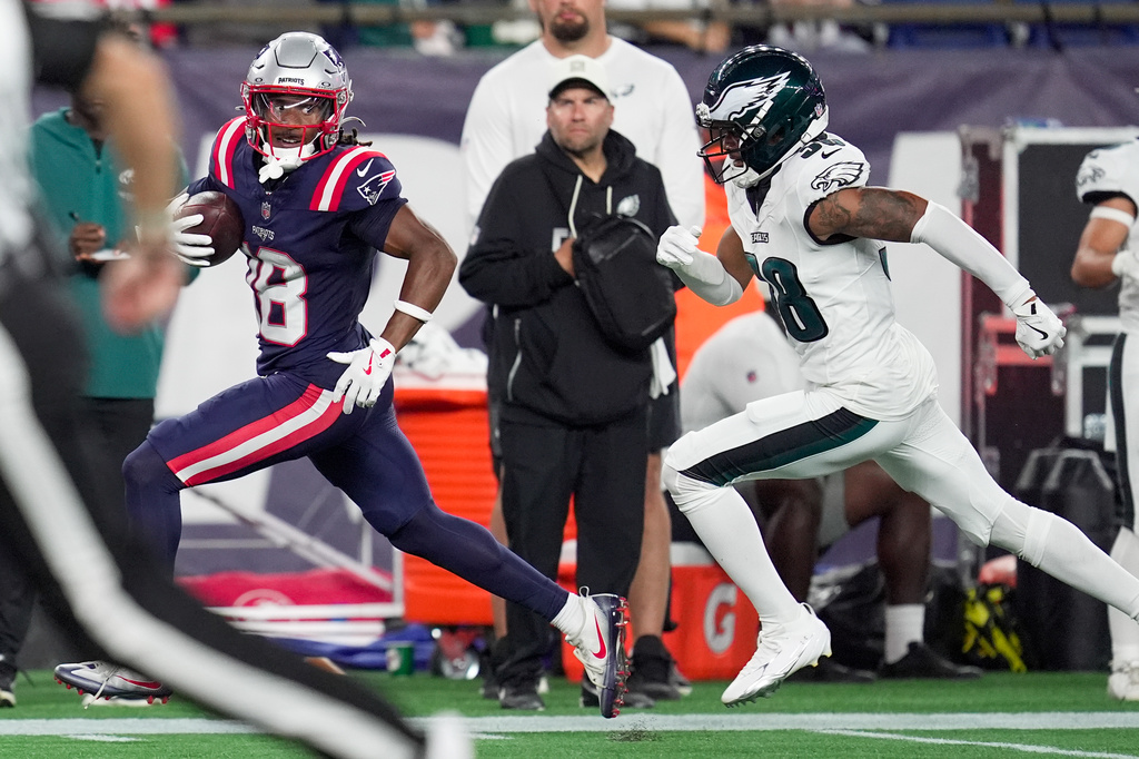 New England Patriots wide receiver Kyle Williams (18) runs for a touchdown as Philadelphia Eagles linebacker Jalyx Hunt (58) pursues during the first half of an NFL preseason football game, Saturday, Aug. 22, 2026, in Foxborough, Mass. (AP Photo/Robert F. Bukaty)