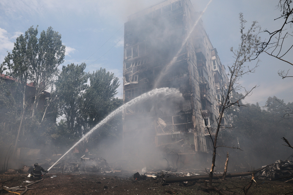Rescue workers try to put out a fire of a residential building burning after a Russian air guided bomb strike in Zaporizhzhia, Ukraine, Tuesday, July 21, 2026. (AP Photo/Kateryna Klochko)