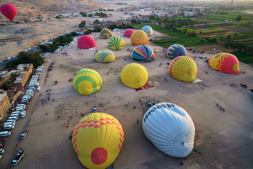 Hot air balloons prepare to take off at dawn, on the west bank of the Nile River in Luxor, Egypt, Oct. 4, 2025. (AP Photo/Amr Nabil)