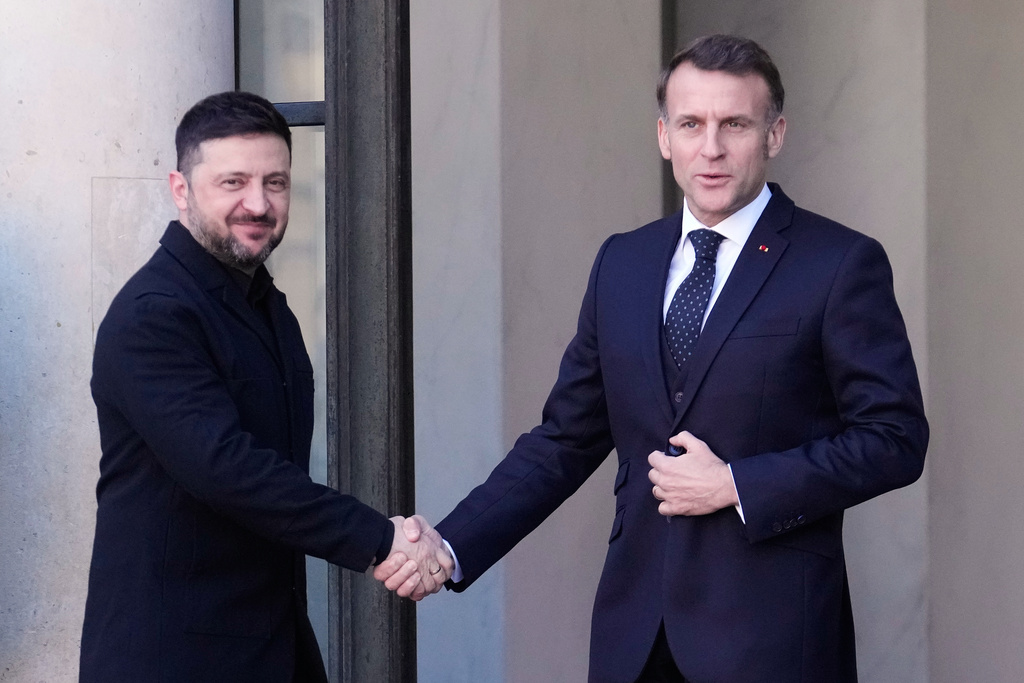 Ukraine's President Volodymyr Zelenskyy, left, is greeted by French President Emmanuel Macron as he arrives for a meeting of the 'Coalition of the Willing' on Ukraine at the Elysee Palace in Paris, France, Tuesday, Jan. 6, 2026. (AP Photo/Michel Euler)