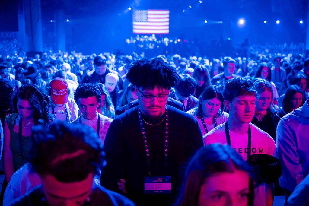 Attendees pray during Turning Point USA's AmericaFest 2025, Thursday, Dec. 18, 2025, in Phoenix. (AP Photo/Jon Cherry)