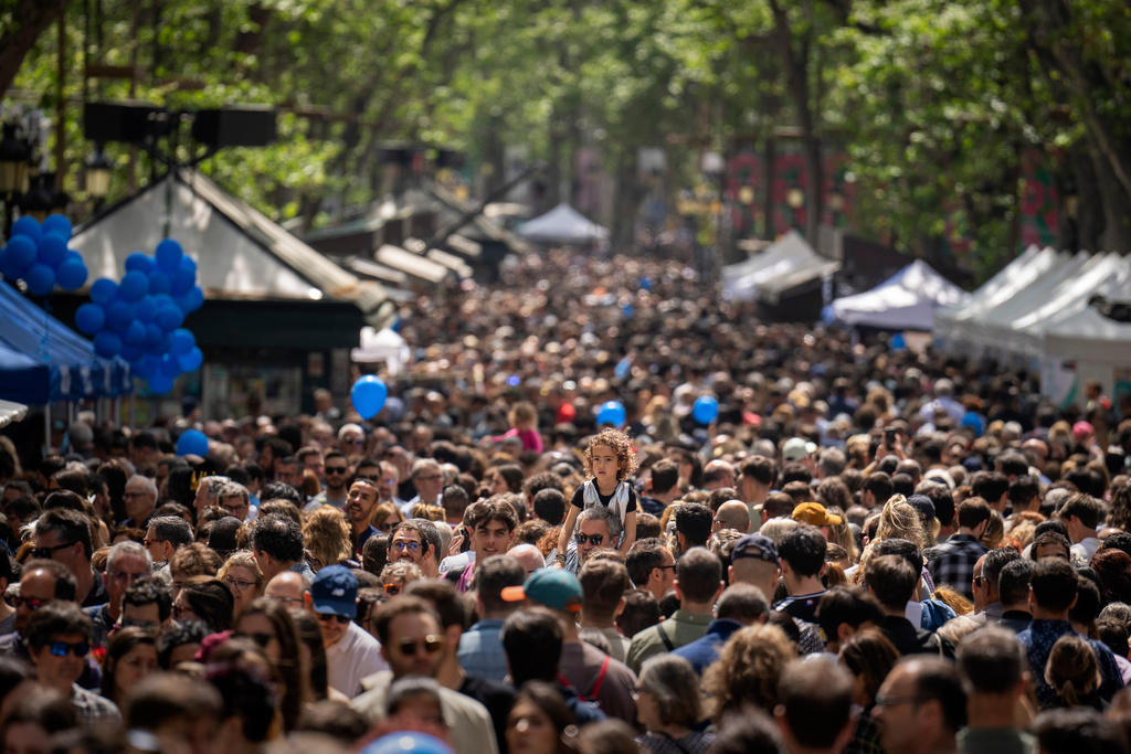 FILE - People crowd along the historic La Rambla promenade of Barcelona as Catalans celebrate the day of their patron Sant Jordi, Spain, Sunday, April 23, 2023. (AP Photo/Emilio Morenatti, File)