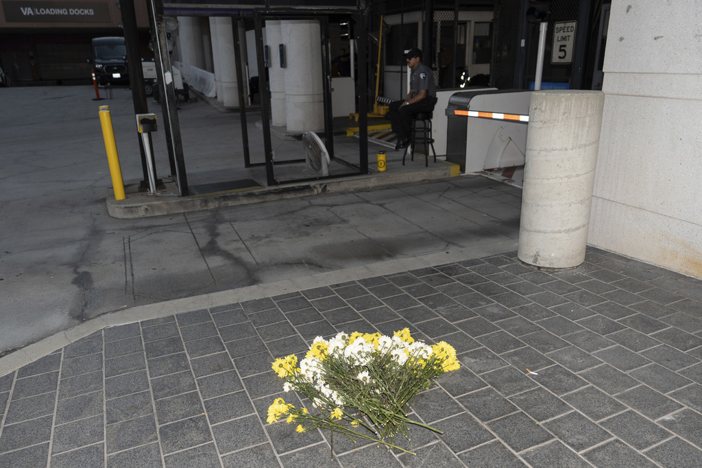 Flowers are placed outside the Metropolitan Detention Center in Los Angeles, Tuesday, Aug. 5, 2025. (AP Photo/Jae C. Hong)