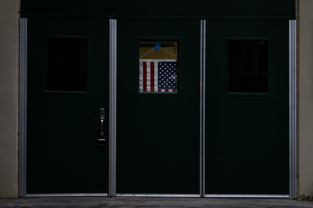 An American flag hangs in the window of a door at a vote center in La Habra Heights, Calif., Tuesday, June 2, 2026. (AP Photo/Jae C. Hong)