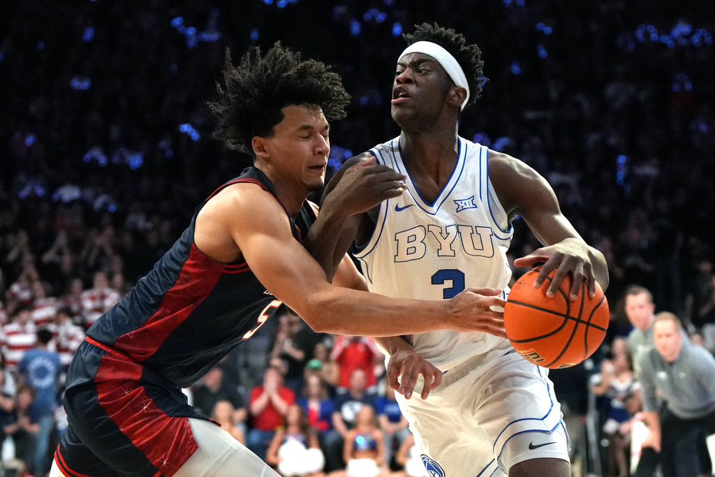 BYU forward AJ Dybantsa (3) drives on Arizona guard Brayden Burries during the first half of an NCAA college basketball game, Wednesday, Feb. 18, 2026, in Tucson, Ariz. (AP Photo/Rick Scuteri)