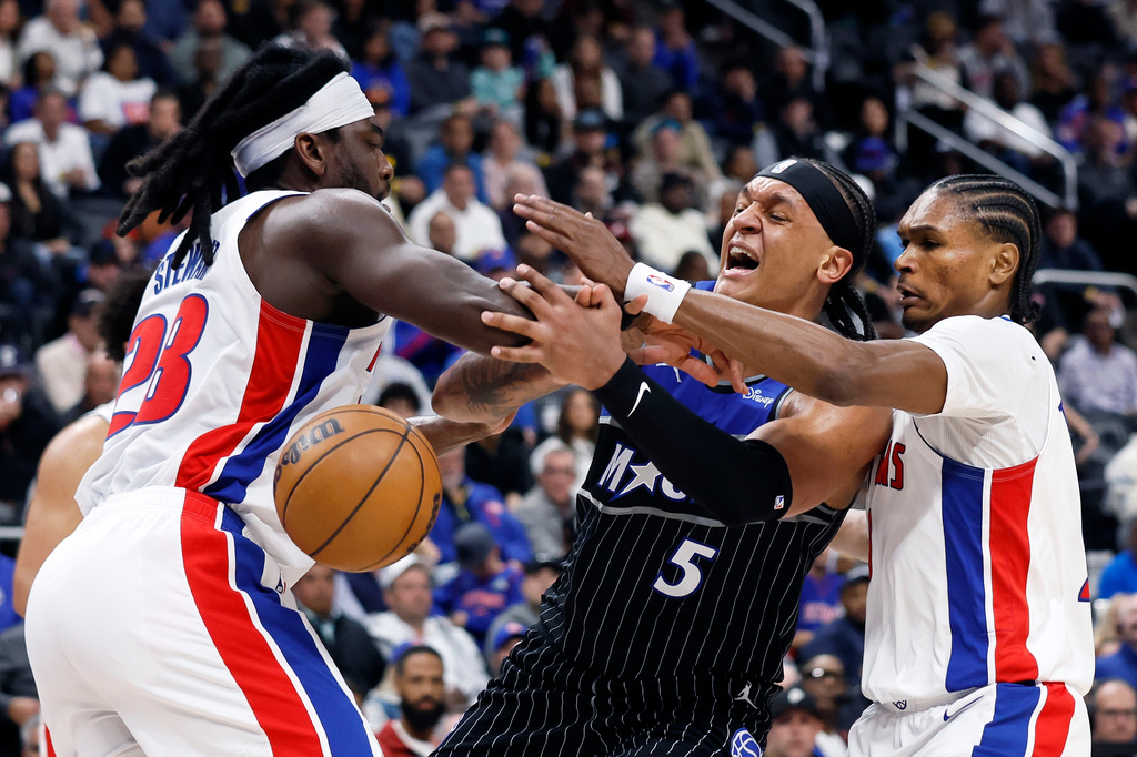 Orlando Magic forward Paolo Banchero (5) loses the ball against the defense from Detroit Pistons forward Isaiah Stewart, left, and guard Ausar Thompson, right, during the second half in Game 5 of a first-round NBA basketball playoffs series Wednesday, April 29, 2026, in Detroit. (AP Photo/Duane Burleson)