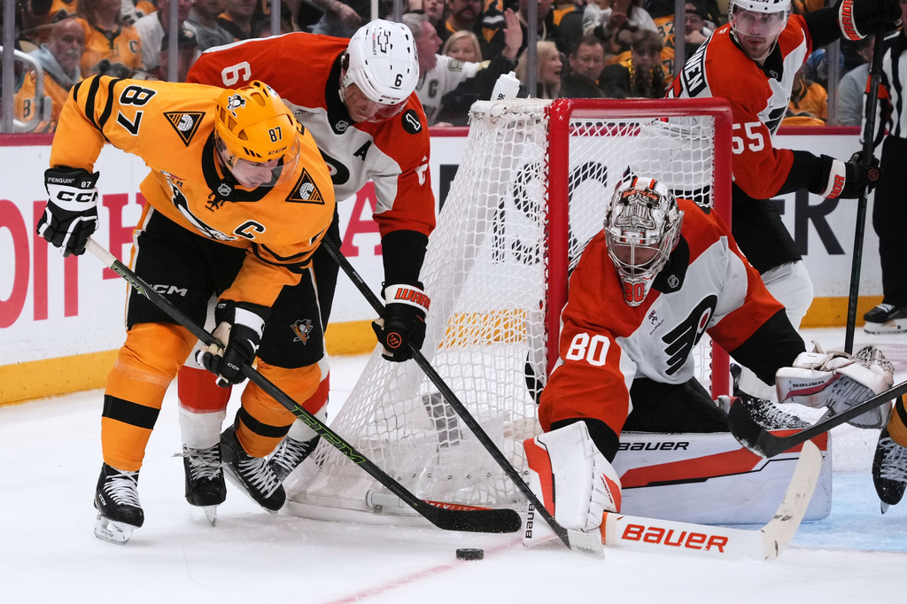 Pittsburgh Penguins' Sidney Crosby (87) cannot shoot against Philadelphia Flyers goaltender Dan Vladar (80) with Flyers' Travis Sanheim (6) defending during the second period of Game 1 in the first round of the NHL Stanley Cup playoffs in Pittsburgh, Saturday, April 18, 2026. (AP Photo/Gene J. Puskar)