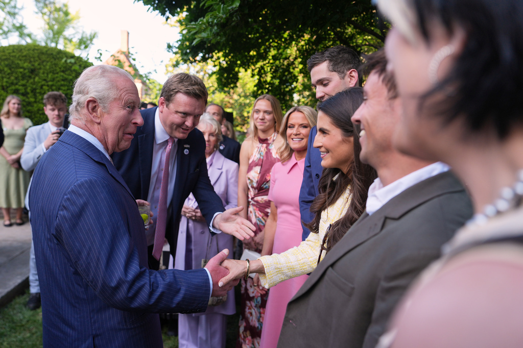 King Charles III shakes hands with CNN news anchor Kaitlan Collins during a garden party at the British Embassy, Monday, April 27, 2026, in Washington. (AP Photo/Julia Demaree Nikhinson, Pool)